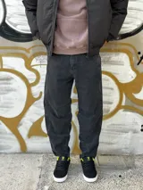 Pantalón de jean negro de corte ancho, con la parte inferior más ancha que la superior.