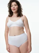 Bralette seamless de microfibra color blanco, con diseño de escote en V, sin relleno y sin aros. Presenta breteles finos ajustables y una banda elástica inferior con textura acanalada.