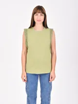 Remera blanca sin mangas con detalle de encaje en los hombros, cuello redondo y corte recto.