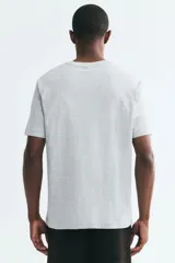 Remera de algodón liviano color gris melange, de cuello redondo y mangas cortas, con corte estándar.