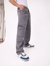 Jean de corte wide leg en color gris con efecto desgastado. Presenta diseño tipo cargo con bolsillos laterales con solapa y costuras reforzadas en las piernas.