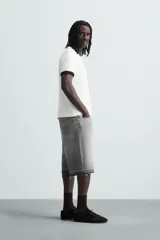 Bermuda de denim de algodón, color negro lavado, de corte ancho (baggy fit) y tiro medio. Presenta cinco bolsillos y bajo con acabado irregular deshilachado.