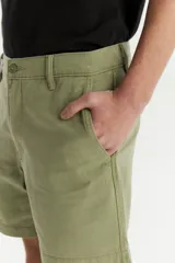 Bermuda de gabardina color verde oliva, corte recto y largo a la rodilla.