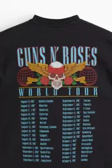 Remera oversized de algodón pesado color negro, con cuello redondo acanalado, hombros caídos y estampa frontal de Guns N' Roses con diseño de calavera y rosas.