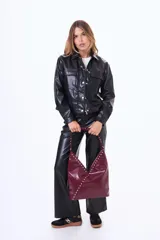 Campera de cuero sintético color negro, con cuello camisero, cierre frontal con cremallera y botones a presión, y bolsillos frontales con solapa.