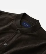 Campera bomber azul marino de pana con cuello redondo, cierre con botones a presión, bolsillos laterales y puños y cintura elastizados.