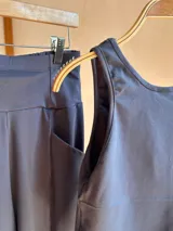 Pantalón palazzo negro de algodón, corte evasé, tiro alto, con bolsillos laterales, elástico en la espalda y faja ancha.