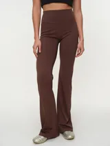Calza larga flare de cintura alta, color gris oscuro, con diseño ajustado en las piernas y botamanga amplia.