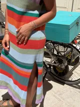 Vestido tejido de punto jersey, silueta recta, sin mangas y con tajo lateral. Presenta un estampado de rayas horizontales en tonos pastel y vibrantes como verde, celeste, naranja, rojo, lila y gris.