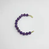 Pulsera de cuentas esféricas de piedra amatista natural de 10 mm, con cierre de mosquetón y terminales con baño de oro.