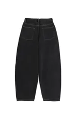 Jean de corte balloon para hombre, confeccionado en denim negro con costuras en contraste. Presenta un diseño de cinco bolsillos, cierre de botón y cremallera, con una silueta amplia y relajada.