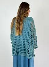 Top tejido al crochet color celeste, con escote en V y mangas largas acampanadas.