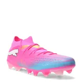 Championes de fútbol Puma Future 9 Match FG/AG, color fucsia con detalles en azul y amarillo. Presentan un diseño de corte medio con cuello tejido elástico, capellada de malla con texturas 3D para mayor control y suela con tapones para césped natural y sintético.