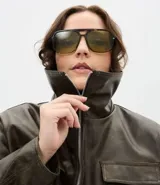 Campera bomber de cuero sintético color verde oliva, con cuello inglés, cierre frontal con cremallera, bolsillos laterales y bolsillos frontales con solapa.