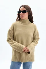 Polera de punto en color verde, con cuello alto, mangas largas con puños acanalados y aberturas laterales en el ruedo.