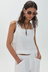 Top de lino blanco con escote cuadrado y tirantes anchos, de corte recto y suelto.