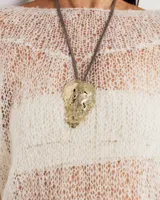 Gargantilla rígida de metal dorado con dije central de diseño orgánico y textura irregular. El diseño permite múltiples usos, incluyendo la opción de utilizar la gargantilla sola o con el dije.
