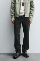 Pantalón de jean corte slim fit, color gris con efecto lavado. Presenta diseño de cinco bolsillos, cierre frontal con cremallera y botón, y tejido elástico.
