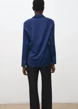 Camisa azul marino de manga larga, con cuello camisero, cierre frontal de botones y puños anchos.
