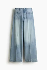Pantalón jean de denim de algodón con leve stretch, tiro alto y pierna ancha. Cuenta con bolsillos tipo parche en el frente y raya marcada en ambas piernas.