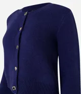 Cardigan azul marino de punto con cuello redondo, mangas largas y textura acanalada. Tiene abotonado delantero con botones mixtos.