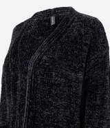 Cardigan abierto de punto chenille con textura aterciopelada, diseño alargado y bolsillos frontales. Presenta terminaciones acanaladas en puños y ruedo, con aberturas laterales para mayor comodidad.