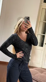 Remera de manga larga con escote en V, confeccionada en jersey térmico con efecto lavado o jaspeado en tonos oscuros.