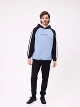 Babucha jogger color gris oscuro, con cintura elástica ajustable con cordón, bolsillos laterales y puños elásticos en los tobillos. Presenta un logo estampado en el muslo izquierdo.