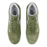 Championes urbanos New Balance modelo 550, color verde oliva con detalles en blanco. Presentan una silueta de corte bajo, confeccionados en cuero sintético con textura de gamuza, logo lateral característico y suela de caucho.