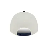 Gorra New Era modelo 9FORTY de los New York Yankees, con diseño bicolor en beige y visera curva en azul marino. Cuenta con el logo bordado del equipo en el frente y el logo de la marca en el lateral.