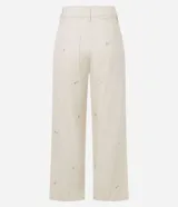 Pantalón de mujer color blanco roto, de corte recto y tiro alto, con un largo cropped y ligero ensanchamiento en el bajo. Presenta detalles bordados florales sutiles en la tela y bolsillos.
