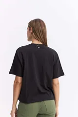 Remera de corte oversize color beige, con cuello redondo y mangas cortas. Presenta un estampado frontal con motivos florales abstractos y la frase 'Ciao Bella' en tonos bordó y crema.