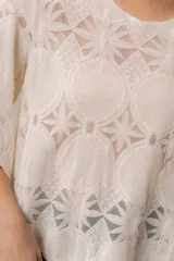 Blusa de punto calado color blanco, con diseño geométrico y floral transparente, escote redondo y mangas tres cuartos amplias de calce relajado.