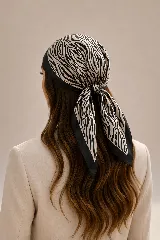 Pañuelo cuadrado de satén con estampado animal print tipo cebra en tonos beige y negro, con borde negro sólido.