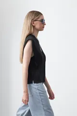 Remera sin mangas negra con hombros marcados y caída recta.