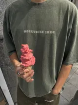 Remera oversize gris con efecto acid wash y estampa frontal con la leyenda "WORLDWIDE TOUR" en tipografía gótica.