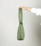 Bolso tipo tote acolchado de color verde oliva, con diseño de costuras horizontales y logo de la marca estampado en el frente. Cuenta con dos asas superiores reforzadas y cierre superior.