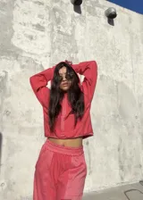 Conjunto deportivo de dos piezas en color rojo, compuesto por un buzo corto con capucha y un pantalón de jogging con cintura elástica.