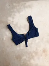 Top de bikini con acabado brillante color verde militar, escote redondo y argolla de madera decorativa en el centro.