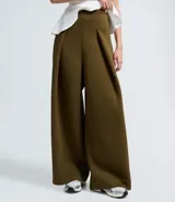 Pantalón de corte barrel color verde oliva, con cintura alta, pliegues delanteros y pernera ancha. Confeccionado en tejido con caída estructurada.