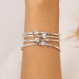 Pulsera rígida abierta de plata 925 con piedra luna central en forma de gota.