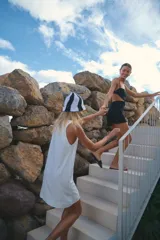 Minivestido negro de lino y rayón con escote recto, breteles regulables y espalda con tiras regulables.