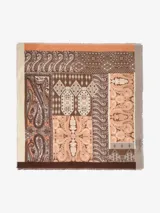 Pañuelo cuadrado con estampado de estilo paisley y geométrico en tonos marrones, beige, naranja y gris. Presenta bordes deshilachados.