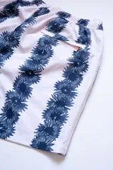 Short de baño blanco con estampado de flores azules, cintura elástica con cordón ajustable, bolsillos laterales y trasero con cierre, y logo bordado en la pierna.