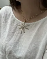 Collar con cadena de eslabones ovalados dorados y dije en forma de estrella con puntas irregulares, también dorado.