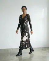 Vestido largo de corte fluido y silueta suave, con escote en V y mangas largas. Confeccionado en tejido de jersey con un estampado exclusivo de trazos orgánicos abstractos en color blanco sobre fondo negro.