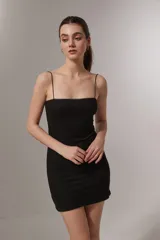 Minivestido negro de punto canalé, con breteles finos y escote recto con detalle de puntilla.