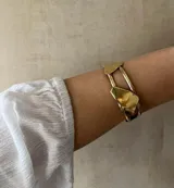 Brazalete rígido dorado con piezas irregulares.