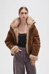 Campera de piel sintética en tono tostado, con cuello alto, cierre frontal y diseño holgado.