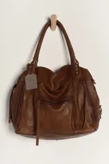 Bolso tote de cuero lavado negro con efecto gastado, interior amplio, bolsillos exteriores con cremallera, dos asas de mano y correa desmontable y regulable.